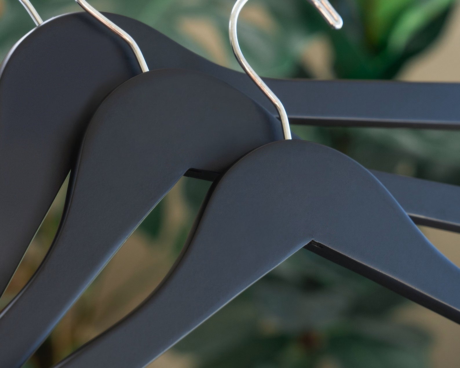 Three Matte Black Wooden Clothes Hangers with silver hooks for custom wedding hanger designers