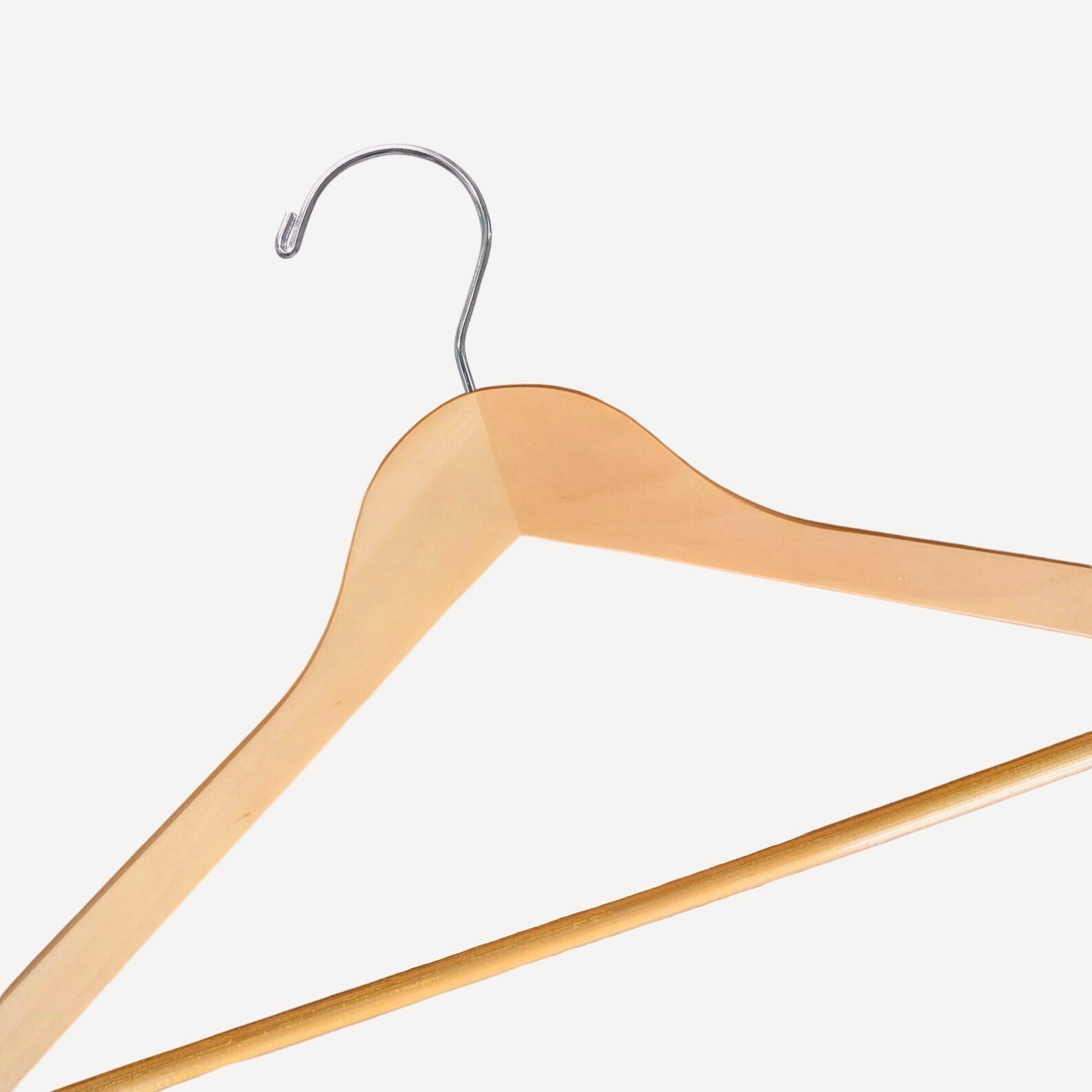A close up of a Natural Wooden Suit Hanger with a silver hook and non-slip pants bar for custom wedding hanger designers