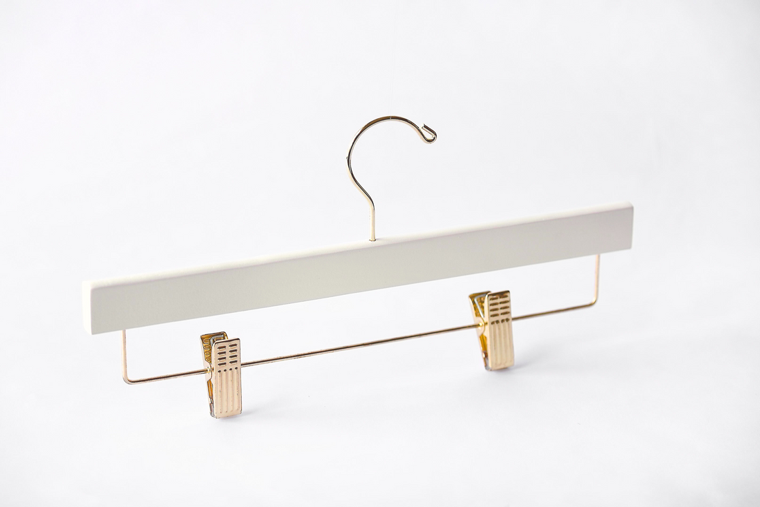 Ivory Wooden Bottom Hanger with a gold hook and adjustable cushion clips for residential closets and retail stores 