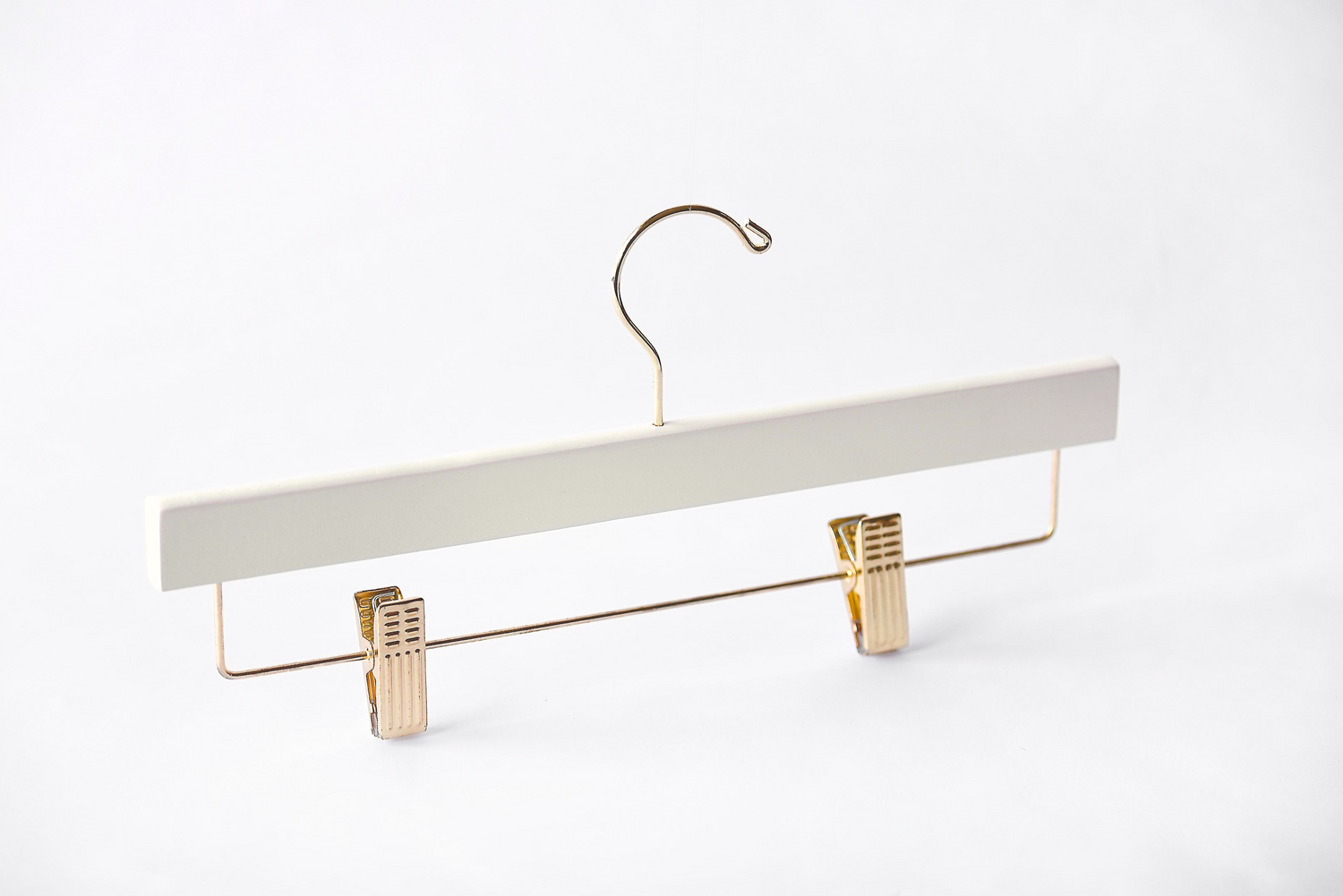 Ivory Wooden Bottom Hanger with a gold hook and adjustable cushion clips for residential closets and retail stores 