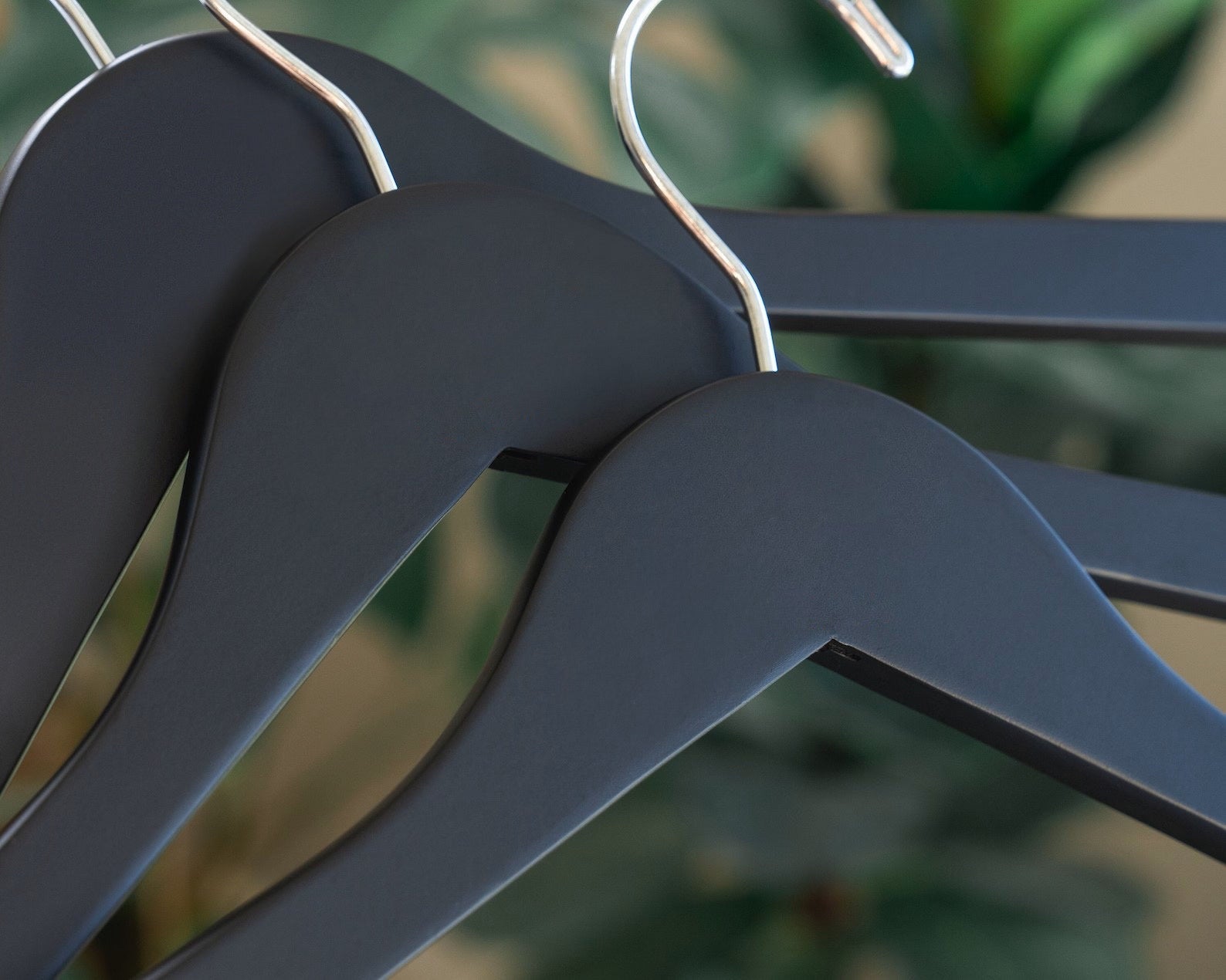 Three Matte Black Wooden Clothes Hangers with silver hooks for custom wedding hanger designers #hook-color_silver-hook