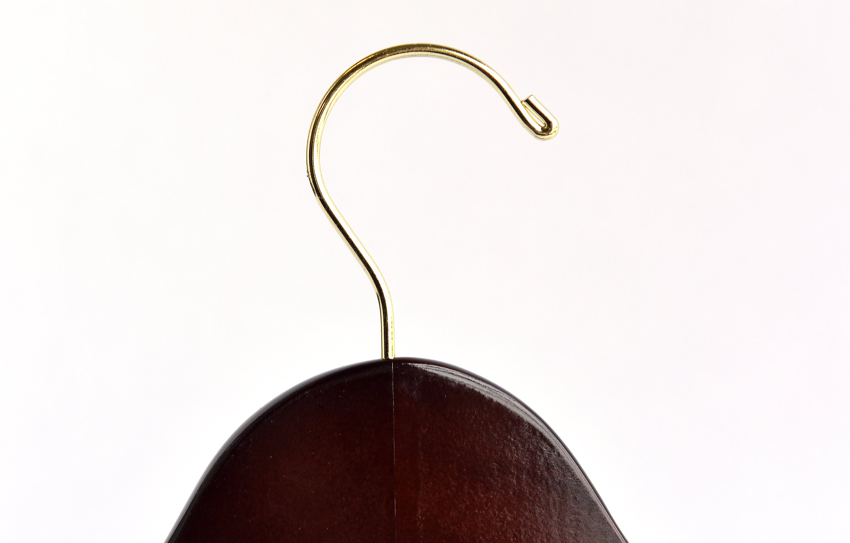 Top of Dark Walnut Wooden Clothes Hanger with a gold hook facing to the right 